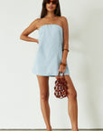 Woven dress. Inner rubber grip lining. Side pockets. Elastic back strap. Back cut out. Partially lined. Blue mini dress. blue strapless mini dress. guest wedding dress. summer dress. summer outfit.