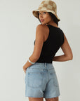 Relax fit mid-length denim shorts. Button fly. Five pocket construction. Raw hem. Unlined. denim shorts. light wash denim shorts. medium wash denim shorts