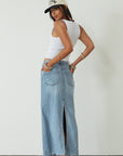 Denim maxi skirt. Button and zipper fly. Five pocket construction. Back slit. Raw hem. Unlined. blue denim maxi skirt. denim maxi skirt with back slit. summer outfit. casual outfit. cute casual outfit.
