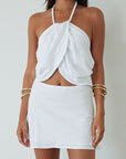 Woven crop top. Beaded halter neckline with adjustable tie closure. Front snap closure. Unlined. white cropped tank top. white halter top. asymmetrical top. summer top. vacation top. vacation outfit