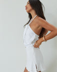 Woven crop top. Beaded halter neckline with adjustable tie closure. Front snap closure. Unlined. white cropped tank top. white halter top. asymmetrical top. summer top. vacation top. vacation outfit