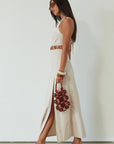 Woven maxi dress. Adjustable halter tie neckline. Back hook and eye and zipper closures. Ring waist details. Front slit. Fully lined. tan maxi dress. beige maxi dress. summer vacation dress.