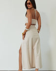 Woven maxi dress. Adjustable halter tie neckline. Back hook and eye and zipper closures. Ring waist details. Front slit. Fully lined. tan maxi dress. beige maxi dress. summer vacation dress.
