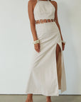 Woven maxi dress. Adjustable halter tie neckline. Back hook and eye and zipper closures. Ring waist details. Front slit. Fully lined. tan maxi dress. beige maxi dress. summer vacation dress.