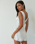 Satin sleeveless crop top. Fixed straps. Front flower detail. Side zipper closure. Back tie closure. Partially lined. white satin tank top. satin tank top. summer top