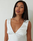 Satin sleeveless crop top. Fixed straps. Front flower detail. Side zipper closure. Back tie closure. Partially lined. white satin tank top. satin tank top. summer top