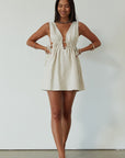 Woven sleeveless dress. Fixed straps. Adjustable drawstring waist. Unlined. tan mini dress. cream mini dress. summer dress. dinner dress. evening dress. vacation dress. vacation outfit