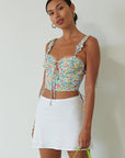 Floral printed woven crop top. Ruffle adjustable tie straps. Underwire cups. Front tie. Adjustable drawstring sides. Ruched bodice. Boning in bodice. Back hook and eye and exposed zipper closure. Fully lined. floral tank top. floral cropped tank. summer top. spring top