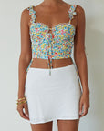 Floral printed woven crop top. Ruffle adjustable tie straps. Underwire cups. Front tie. Adjustable drawstring sides. Ruched bodice. Boning in bodice. Back hook and eye and exposed zipper closure. Fully lined. floral tank top. floral cropped tank. summer top. spring top