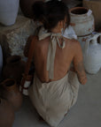 Woven dress. Adjustable halter neckline with tie closure. Back hook and eye and zipper closures. Fully lined. European summer. European summer dress. European summer aesthetic. Tuscany outfit inso. Tuscany aesthetic. Summer dress. oat mini dress. beige mini dress. tan mini dress. mini halter neck dress. summer outfit. everyday dress. vacation dress. outfit to wear to tuscany. nice dinner dress. dinner dress. day dress.
