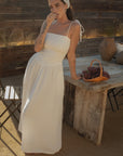 Sleeveless maxi dress. Elastic smocked bodice. Gauze skirt. Adjustable toe straps. Side pockets. Partially lined. European summer aesthetic. Tuscany outfit inso. Tuscany aesthetic. Summer dress. white maxi dress. summer outfit. everyday dress. vacation dress. outfit to wear to tuscany. day dress. white ruffled maxi dress. shoulder tie strap dress