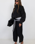 black Windbreaker material track pant
Mid rise
Ankle length
4 pocket construction
Adjustable elastic drawstring