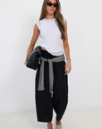 black Windbreaker material track pant
Mid rise
Ankle length
4 pocket construction
Adjustable elastic drawstring
