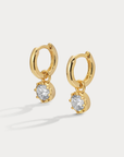 A modern bezel set charm hoop that pairs clean design with luminous sparkle
Available in 14kt gold plated brass or Rhodium plated brass
Stones are white cz and measure 5.0mm each
Huggie measures 8mm inner diameter.
Snap Hinge Closure
Sold as a pair
gold cz hoop earring