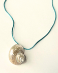 Turbo shell silk cord necklace
Polished and hand-drilled
Silk cord with gold plated beads
Can be worn multiple ways
Length: 26"
Turbo shell approx. 1.5"
Size color and shape of shell may vary slightly