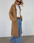 Fuzzy heather knit longline cardigan. Collar neckline. Long sleeves. Front pockets. Open front. Unlined. fall cardigan. tan long cardigan