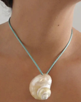 Turbo shell silk cord necklace
Polished and hand-drilled
Silk cord with gold plated beads
Can be worn multiple ways
Length: 26"
Turbo shell approx. 1.5"
Size color and shape of shell may vary slightly