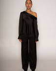 black Satin top. Folded off the shoulder neckline. Long sleeves with button closures. Unlined. black satin off the shoulder top.