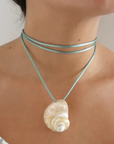 Turbo shell silk cord necklace
Polished and hand-drilled
Silk cord with gold plated beads
Can be worn multiple ways
Length: 26"
Turbo shell approx. 1.5"
Size color and shape of shell may vary slightly