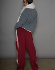 Woven burgundy track pants. Elastic waistband. Side pockets. Side stripes. Unlined. street fashion. trendy track pants