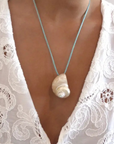 Turbo shell silk cord necklace
Polished and hand-drilled
Silk cord with gold plated beads
Can be worn multiple ways
Length: 26"
Turbo shell approx. 1.5"
Size color and shape of shell may vary slightly