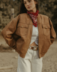 Tan brown faux suede jacket. Front zipper closure. Front and side pockets. Long sleeves with button closures. Fully lined. suede bomber jacket