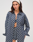 Denim polka dot button-down long sleeve top
Collared
Functional buttons at cuff
Pleat at center-back from waist to hem
Unlined
Cotton