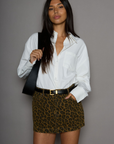 Animal printed denim skirt. Button and zipper fly. Five pocket construction. Frayed hem. Unlined. leopard mini skirt. going out mini skirt.