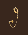 Designed in 14K gold plating, this design features an ear cuff enhanced by a delicate chain that attaches to a glistening cubic zirconia crystal stud, giving you a vibrant sparkle. 
