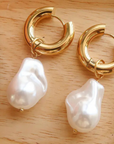 Small thick hoop earrings with pearl drop detail. Hinge closure.