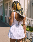 Woven sleeveless dress. Drop waist. Bubble skirt. Side hook and eye and zipper closures. Adjustable lace up back closure. Fully lined. white mini bubble skirt. summer dress. vacation dress. vacation outfit. nice dress. european summer dress. european summer outfit. european summer vacation