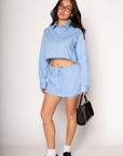 Striped woven cropped shirt. Collar neckline. Long sleeves with button closures. Front button down closures. Drawstring side ties. Unlined. blue stripe crop top. studious oufit