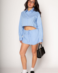 Striped woven skort. Elastic waistband with drawstring closure. Faux front button down closures. Shorts lining. blue stripe skort. blue stripe top skort