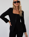 black Woven blazer style top. Long sleeves with faux button closures. Square neckline. Front button down closure. Faux front pockets. Fully lined. black fall top. work top