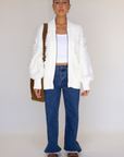 white Fringe crochet knit sweater
Front zipper closure
Long sleeves
Side pockets
Banded hems
Unlined