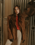 Faux suede single breasted blazer. Collar neckline. Front button closures. Front pockets. Long sleeves with faux button closures. Back slit. Fully lined. brown suede blazer.