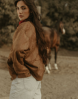 Tan brown faux suede jacket. Front zipper closure. Front and side pockets. Long sleeves with button closures. Fully lined. suede bomber jacket