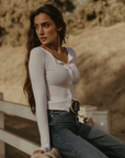 Ribbed knit top. Long sleeves. With elastic sleeve openings. Front button down closures. Unlined. Crochet lace trim. White long sleeve