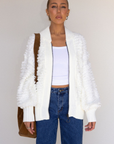 white Fringe crochet knit sweater
Front zipper closure
Long sleeves
Side pockets
Banded hems
Unlined