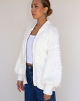 white Fringe crochet knit sweater
Front zipper closure
Long sleeves
Side pockets
Banded hems
Unlined