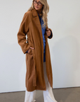 brown Vegan wool trench coat. Collar neckline. Long sleeves. Tie waist. Side pockets. Unlined. tan trench coat. fall outfit. fall jacket