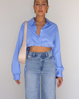 Striped woven cropped shirt. Collar neckline. Long sleeves with button closures. Front button down closures. Drawstring side ties. Unlined. blue stripe crop top. studious oufit