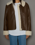 brown Faux leather jacket. Faux Sherpa trim and lining. Front zipper closure. Side pockets. winter jacket. winter coat. fall jacket. fall coat.