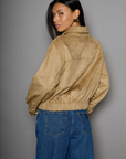 Vegan suede bomber jacket. Collar neckline. Front zipper closure. Elastic hems. Front pockets with snap button closures. Fully lined. tan suede bomber