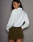 Animal printed denim skirt. Button and zipper fly. Five pocket construction. Frayed hem. Unlined. leopard mini skirt. going out mini skirt.