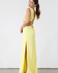 Crinkle woven sleeveless maxi dress. Waist cut outs. Side slits. Back tie closure. Back drawstring waist closure. Partially lined. vacation dress. beach dress. yellow maxi dress.