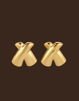 Gold 'X' shaped earrings on a dark brown background