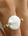 Gold ring with a large pearl
18K Gold Non-Tarnish Baroque Pearl Ring
18K Gold Plating
Stainless Steel
Faux Pearl
Size 7 Measurement: 0.682 Diameter/2.14 Circumference
Lead-free
Nickel-safe
Hypoallergenic
Water Resistant