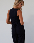 Plaid woven sleeveless top. Front button down closure. Faux front pockets. Adjustable back tie closure. Fully lined. navy blue blouse. work outfit. business casual outfit.