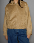 Vegan suede bomber jacket. Collar neckline. Front zipper closure. Elastic hems. Front pockets with snap button closures. Fully lined. tan suede bomber